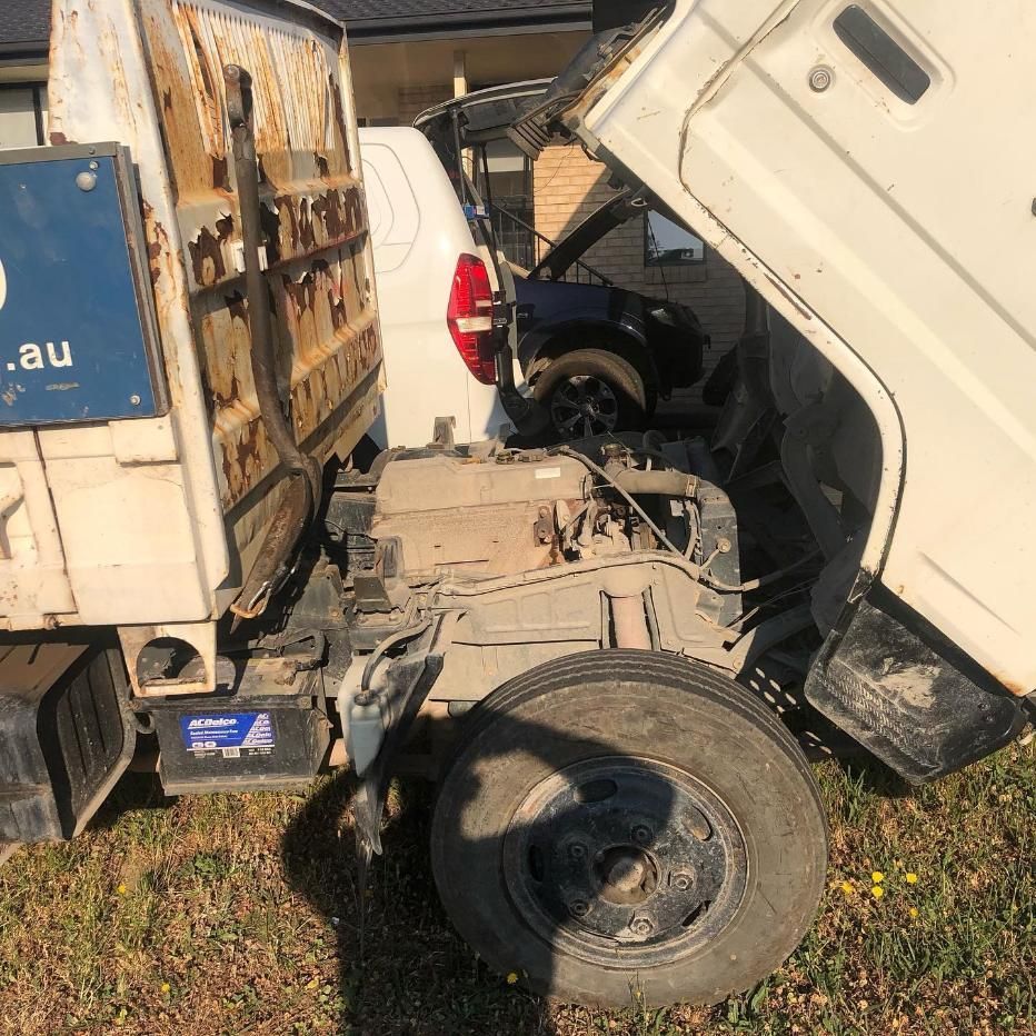 A White Truck With The Hood Up Is Parked In A Grassy Field — SG Mobile Mechanic In Lake Macquarie, NSW