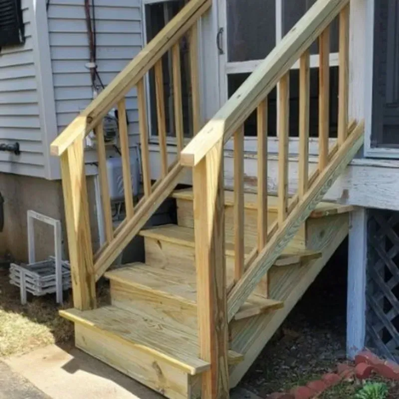 A set of wooden stairs leading up to a screened in porch