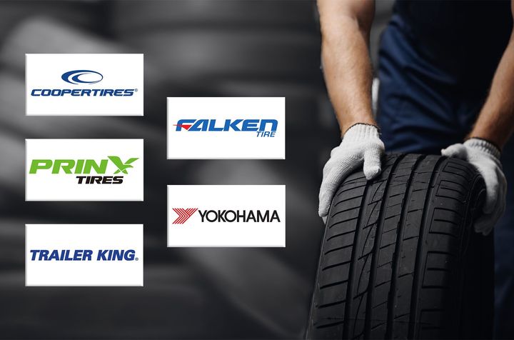 A man is holding a tire in his hands with logos for different tire companies.