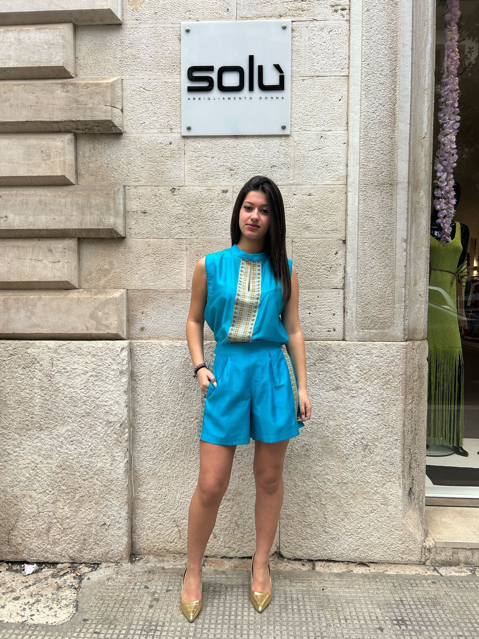 Una donna è in piedi davanti a un edificio con un cartello che dice solu.