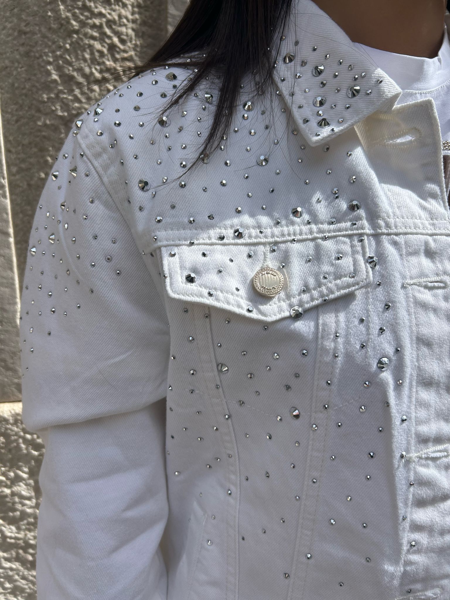 Una donna che indossa una giacca bianca con strass