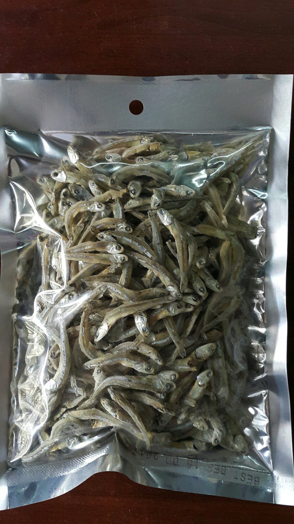 Bag of dried, small silver fish; product packaging.