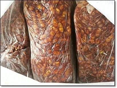 Three plastic bags filled with brown tamarind.