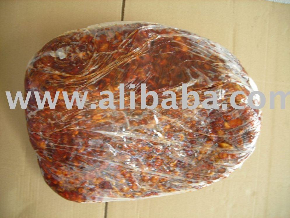 A large brick of reddish-brown, wrapped food, possibly chorizo, in clear plastic, on a surface.