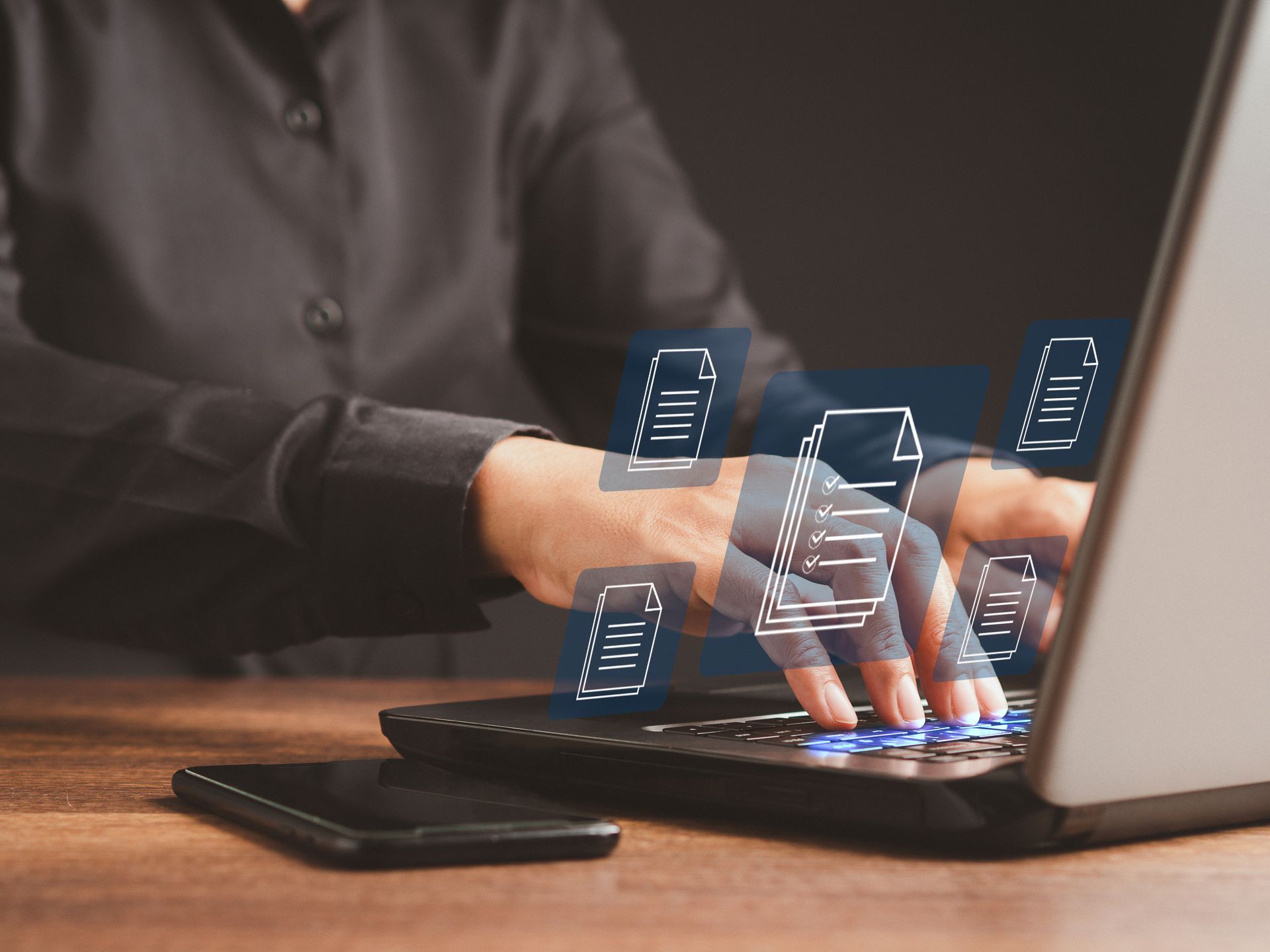 Hands typing on a laptop with glowing, floating digital document icons appearing above the keyboard. Hands typing on a laptop with glowing, floating digital document icons appearing above the keyboard.
