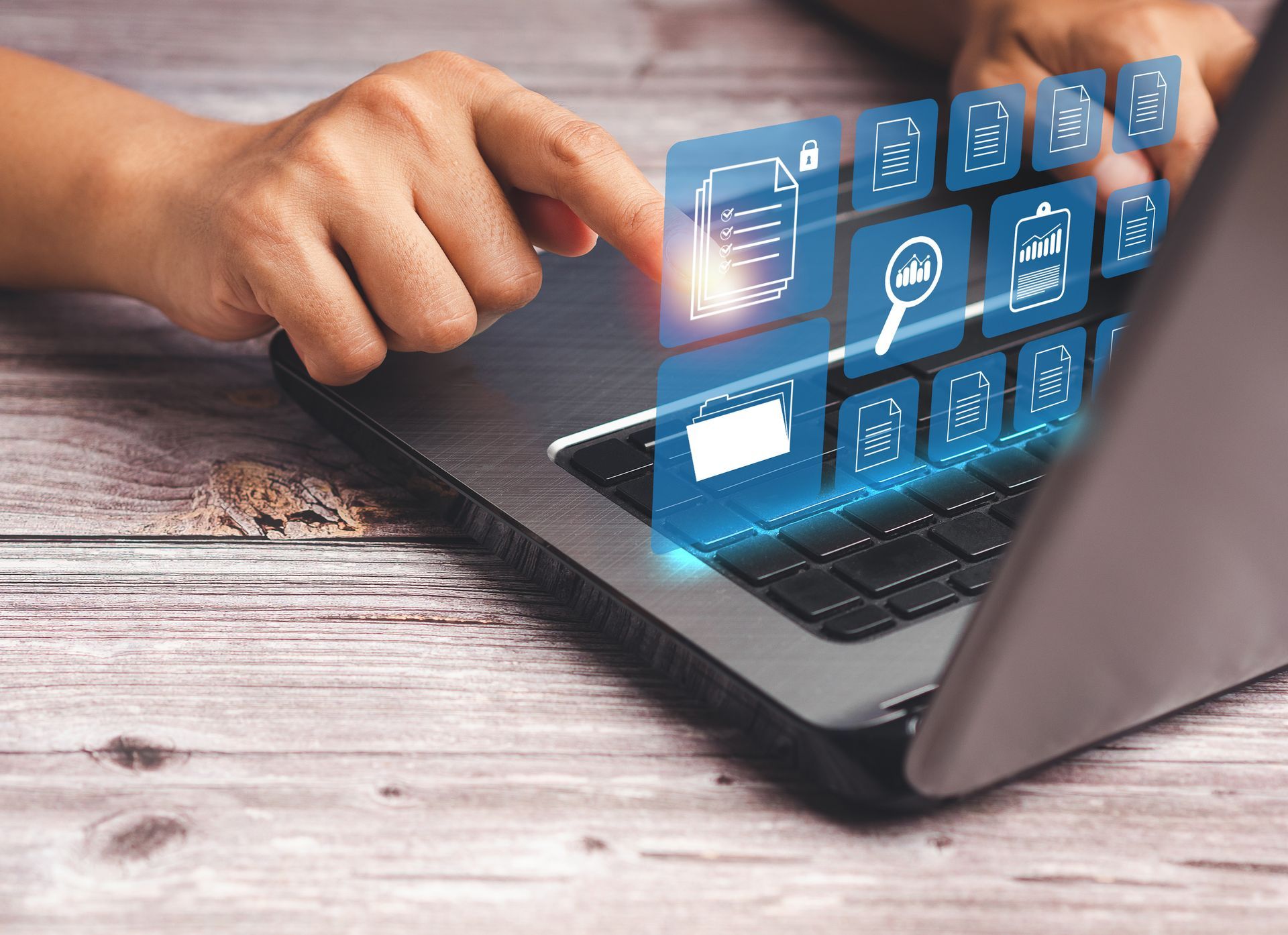 A person touching a laptop keyboard with a digital overlay of glowing business and data analysis icons. A person touching a laptop keyboard with a digital overlay of glowing business and data analysis icons.