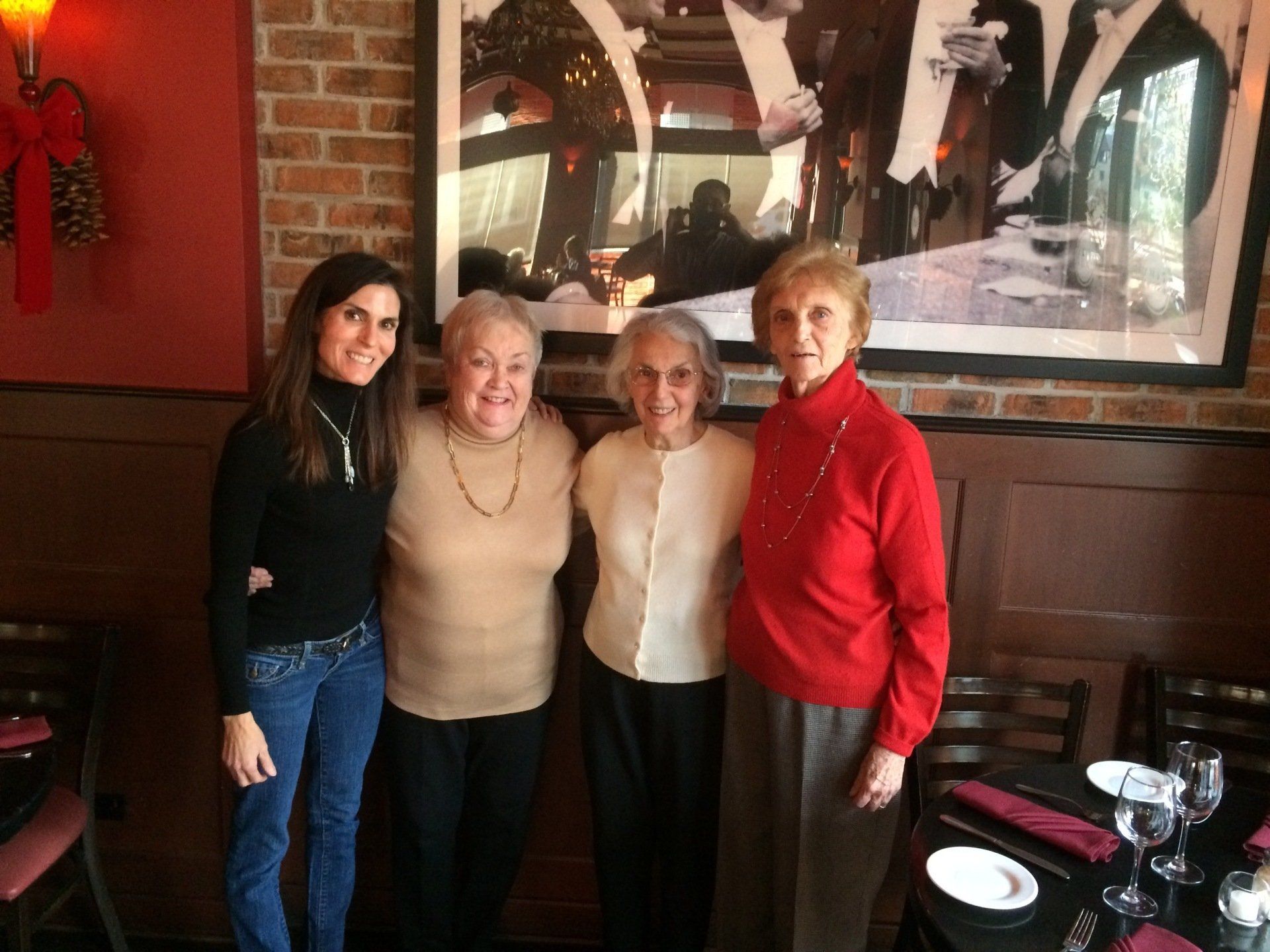 Beth Frates MD standing with friends next to a painting.
