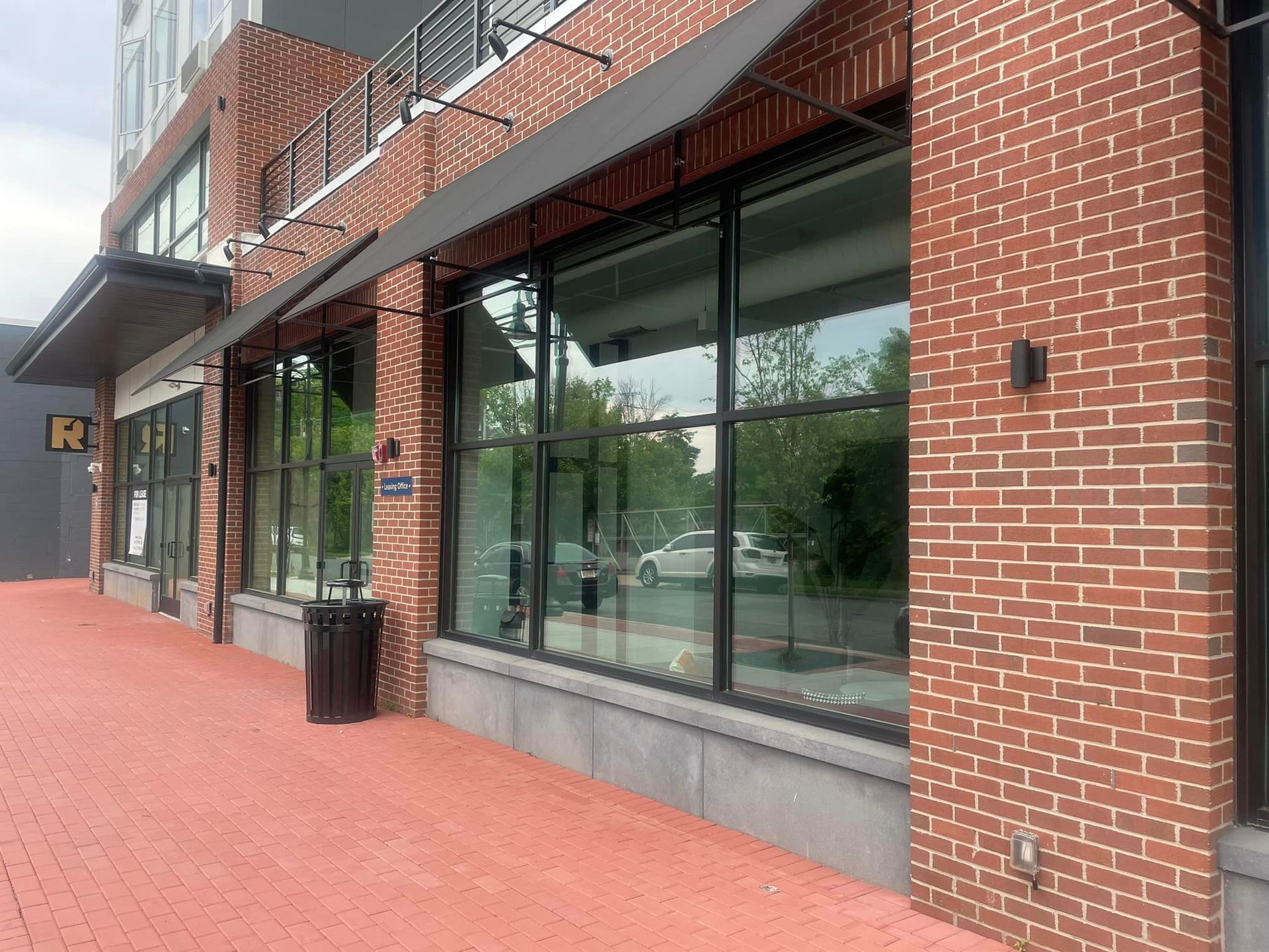A brick building with a lot of windows and a black awning.