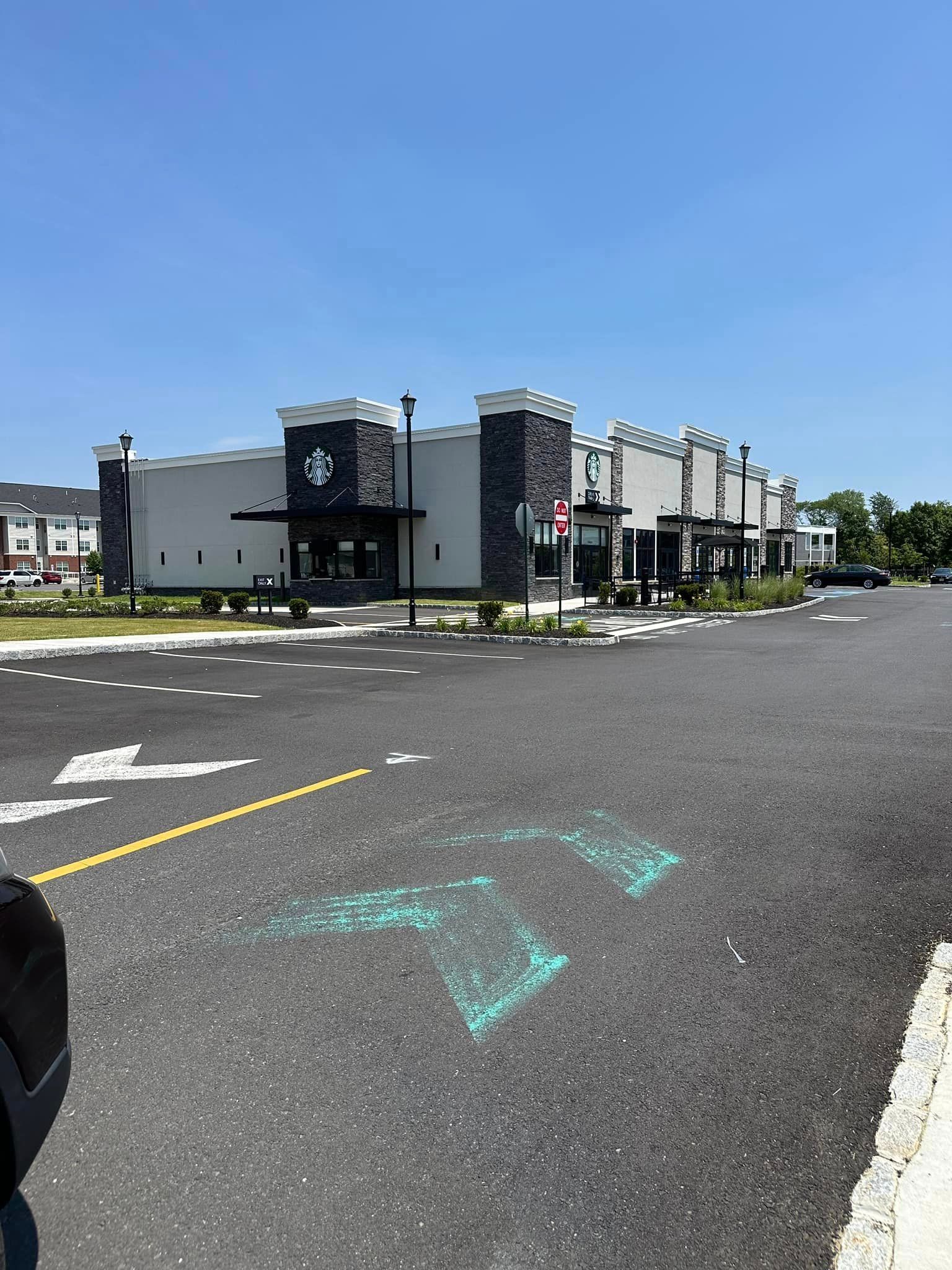 A parking lot with a starbucks restaurant in the background.