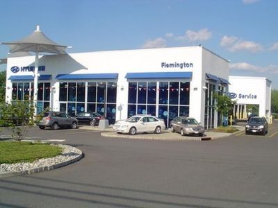 A white car dealership building with the word Flemington on it