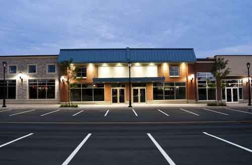 A row of buildings with empty parking spaces in front of them.