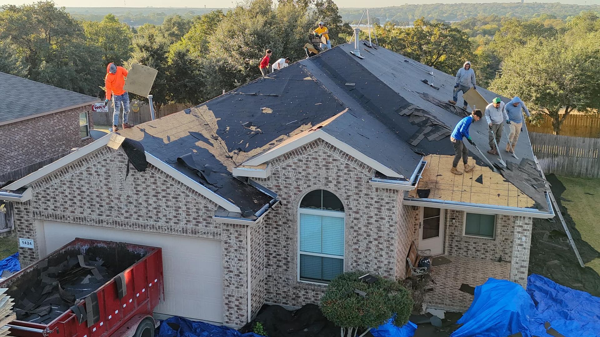 A group of people are working on the roof of a house.