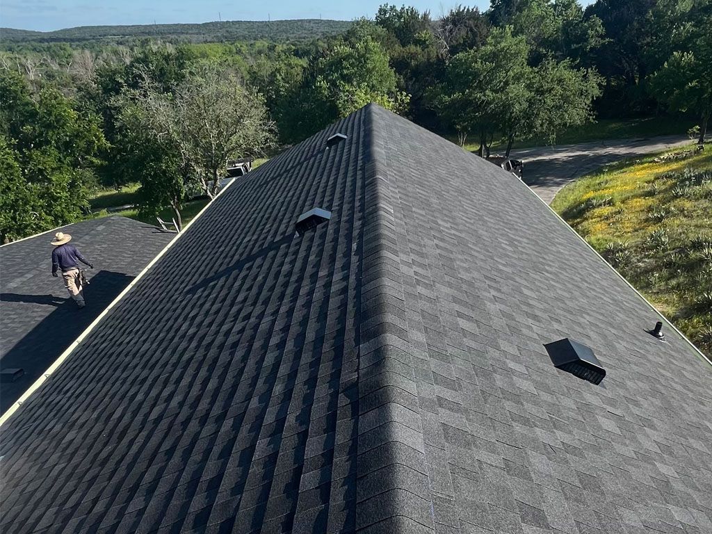 A man is standing on the roof of a house.