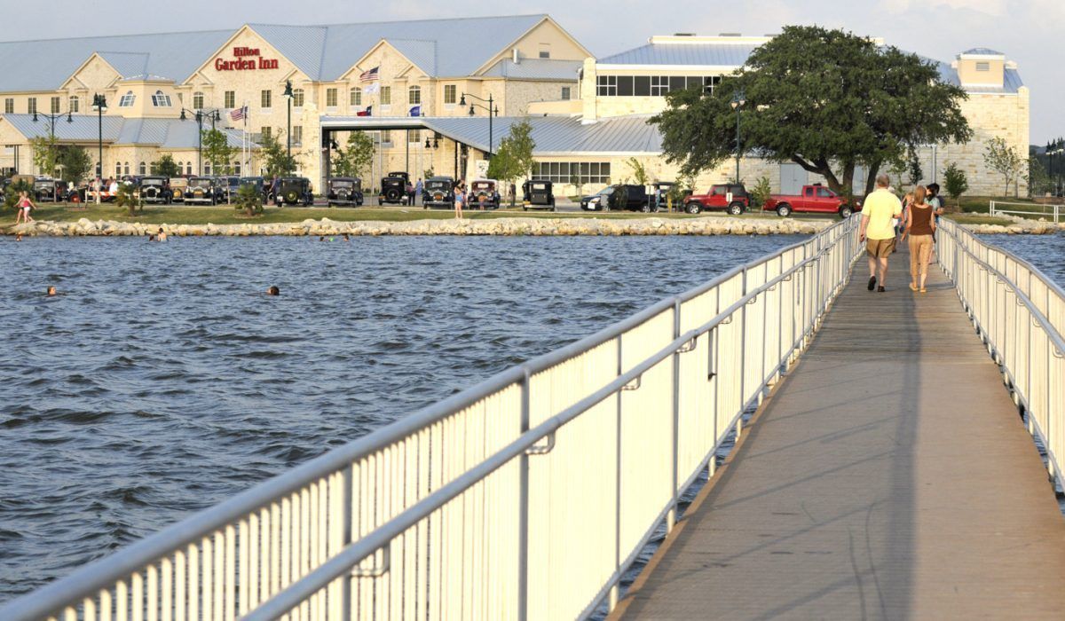 A bridge over a body of water with a building in the background