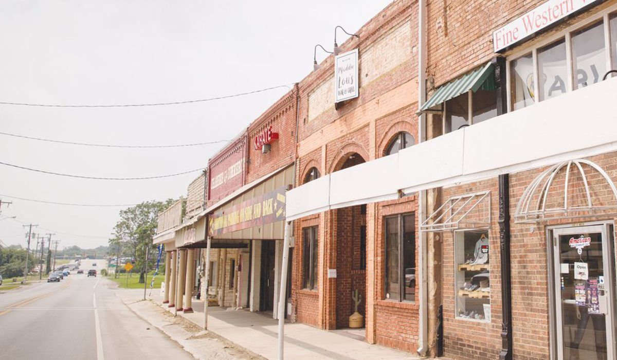 A row of brick buildings along a street in a small town.