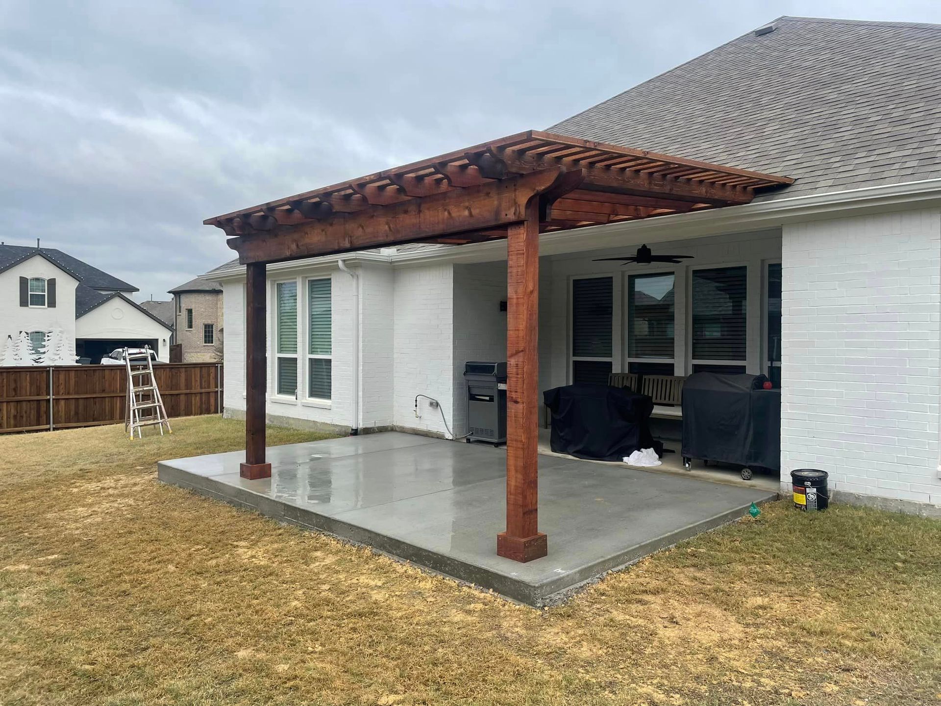 There is a pergola in the backyard of a house.