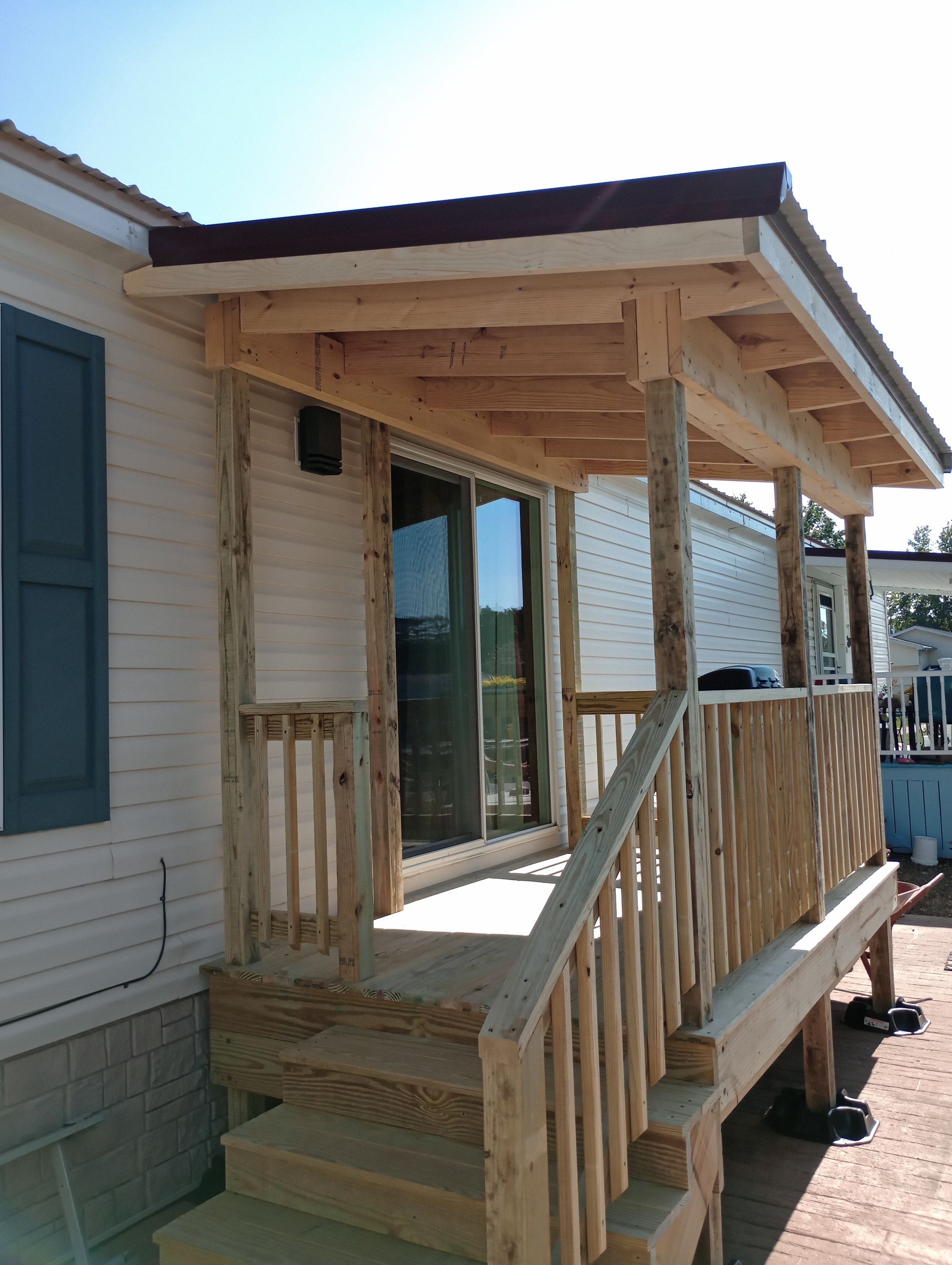 A mobile home with a wooden porch and stairs
