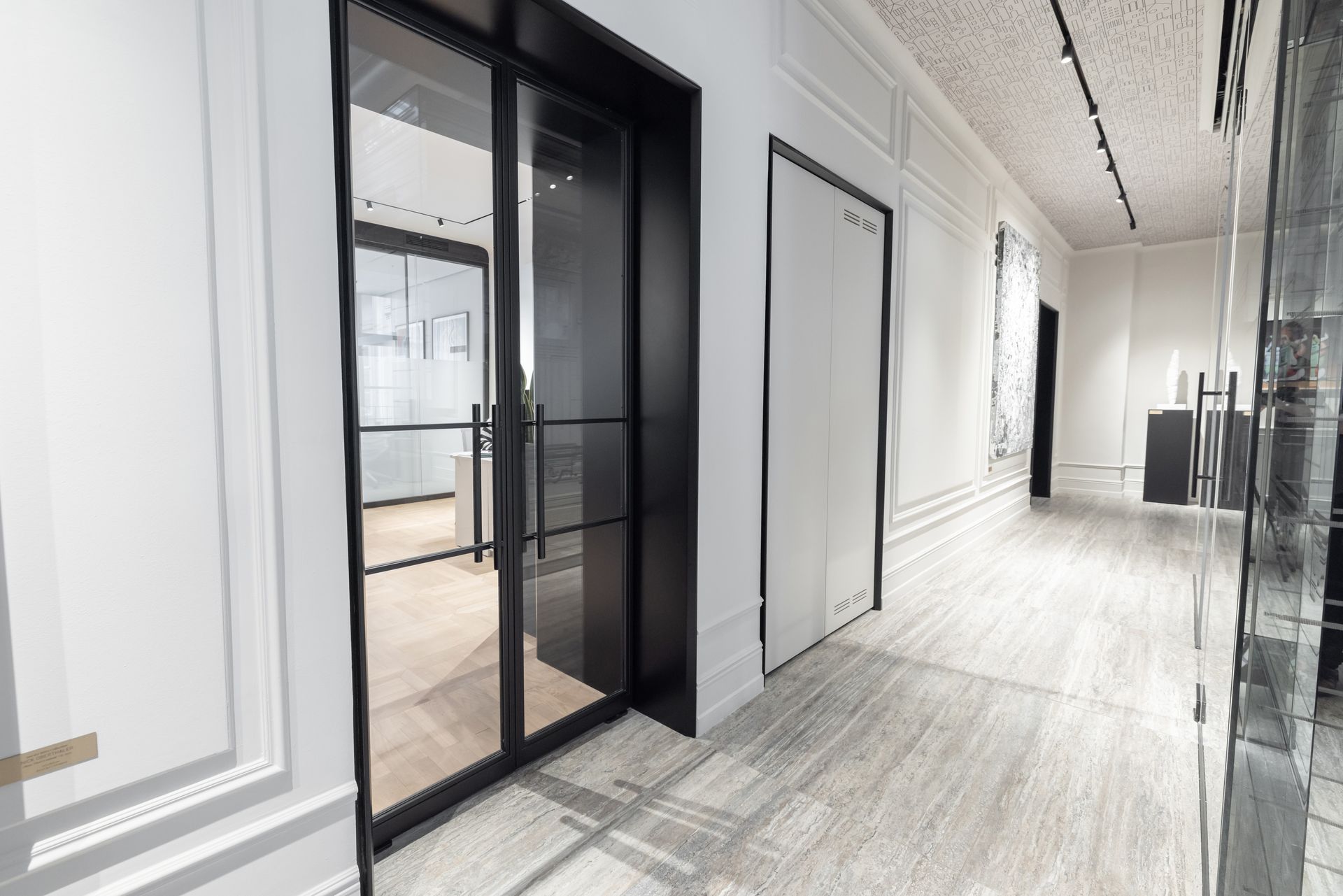 Restaurant-Interieur: Holzwände, mit Besteck gedeckte Tische, kupferfarbene Theke, schwarze Pendelleuchten.