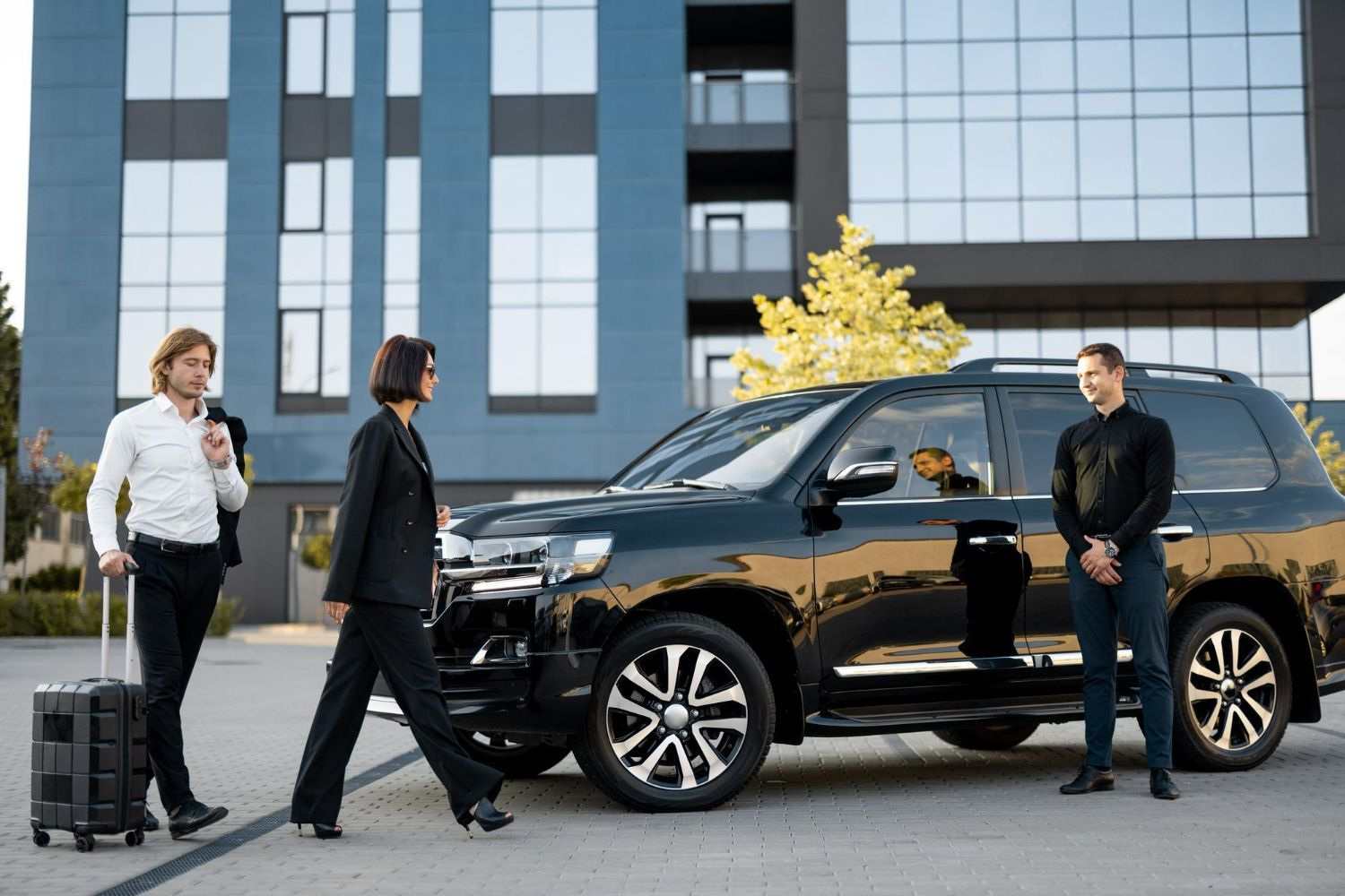 A man and a woman are standing next to a car.