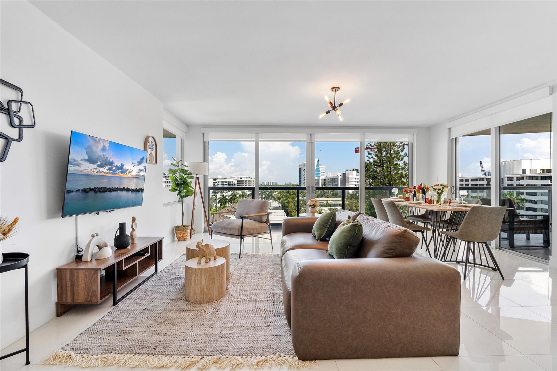 Modern living room with large windows, beige sofa, and dining area.