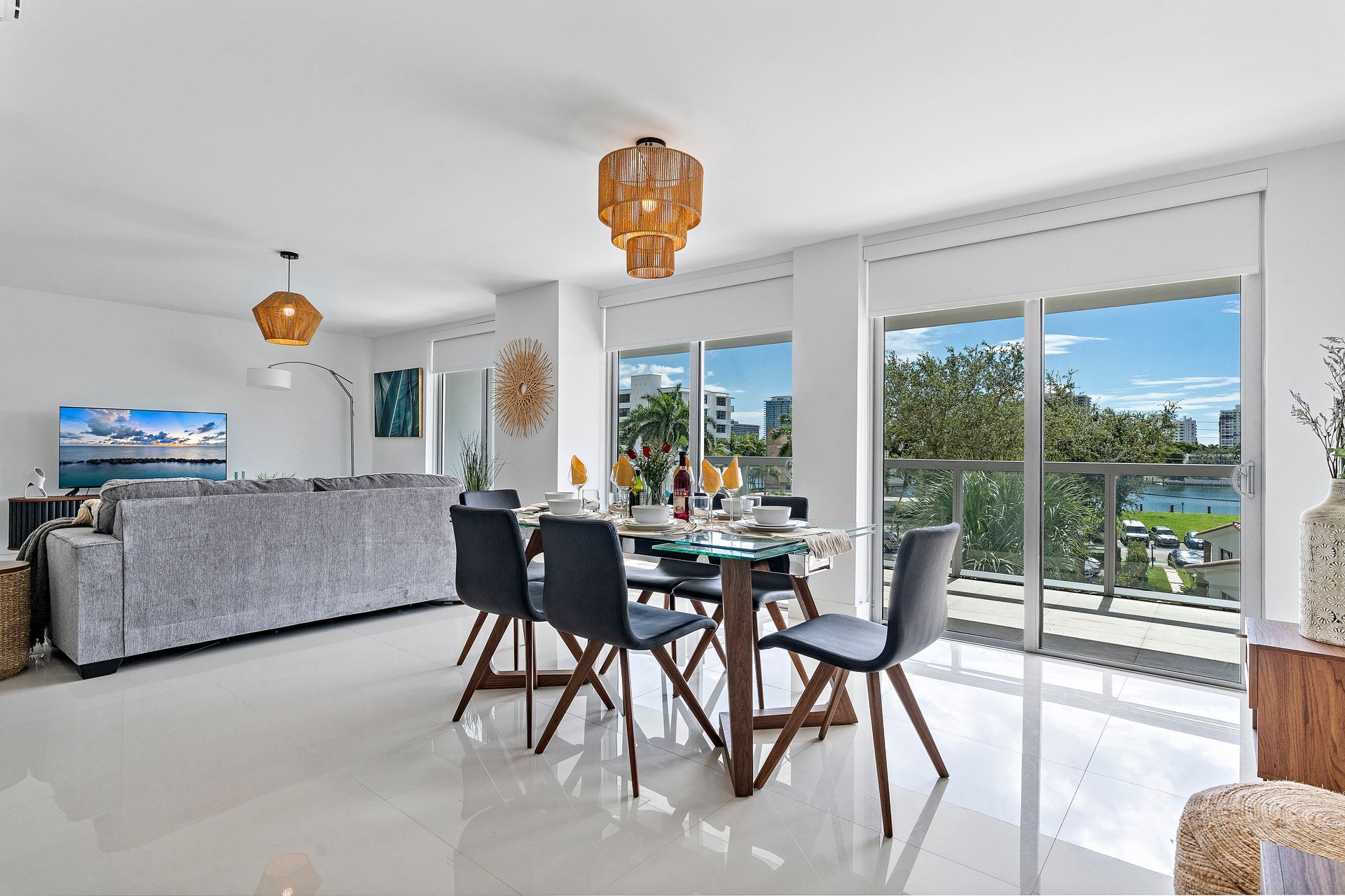 Bright, modern dining area with table, chairs, and large windows overlooking a cityscape.