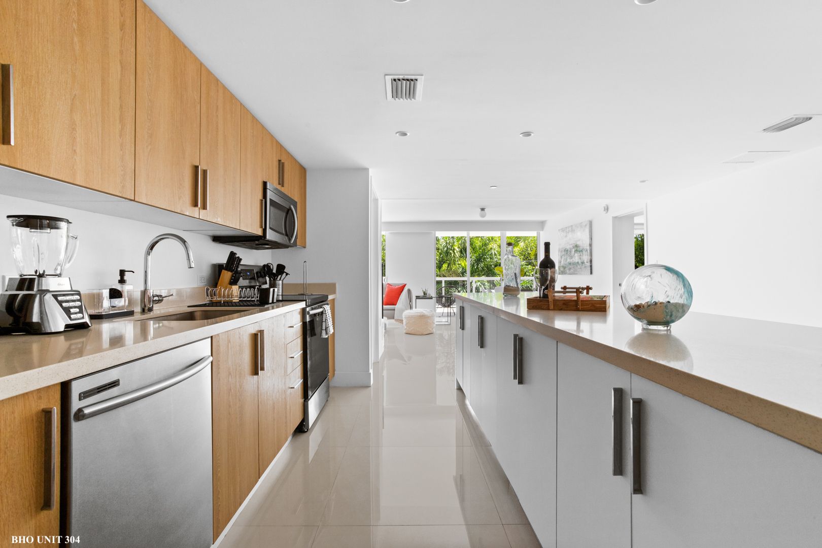 Modern kitchen with wood cabinets, stainless steel appliances, and white island.