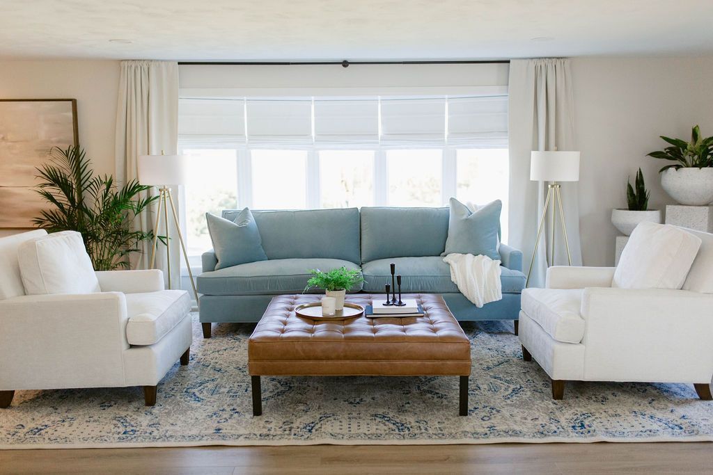a living room with a blue couch , white chairs , and a custom coffee table by CM Design Interiors