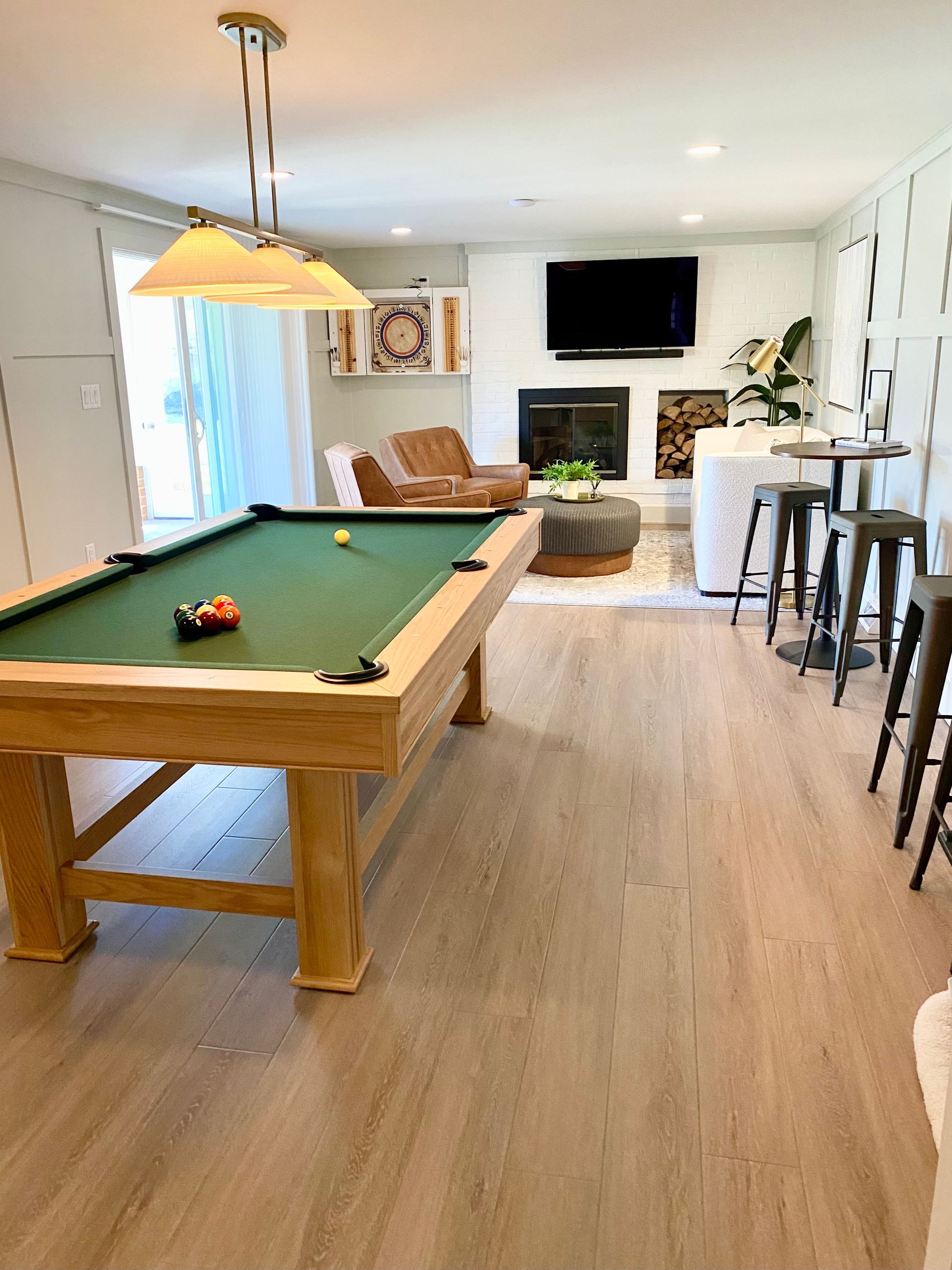 a pool table is in the middle of a living room .