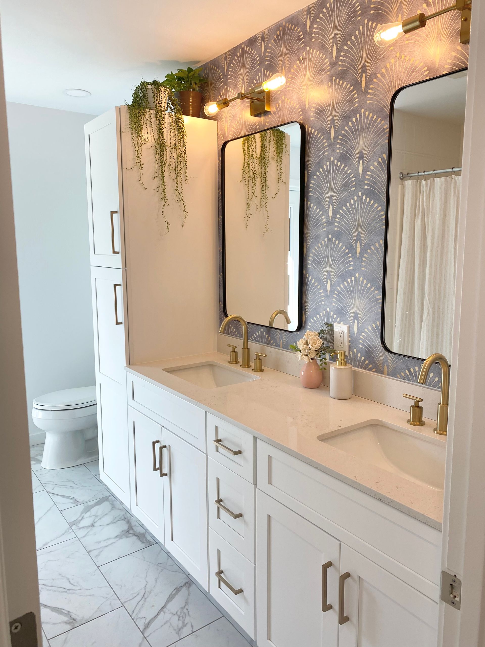 a bathroom with two sinks , two mirrors and a toilet .