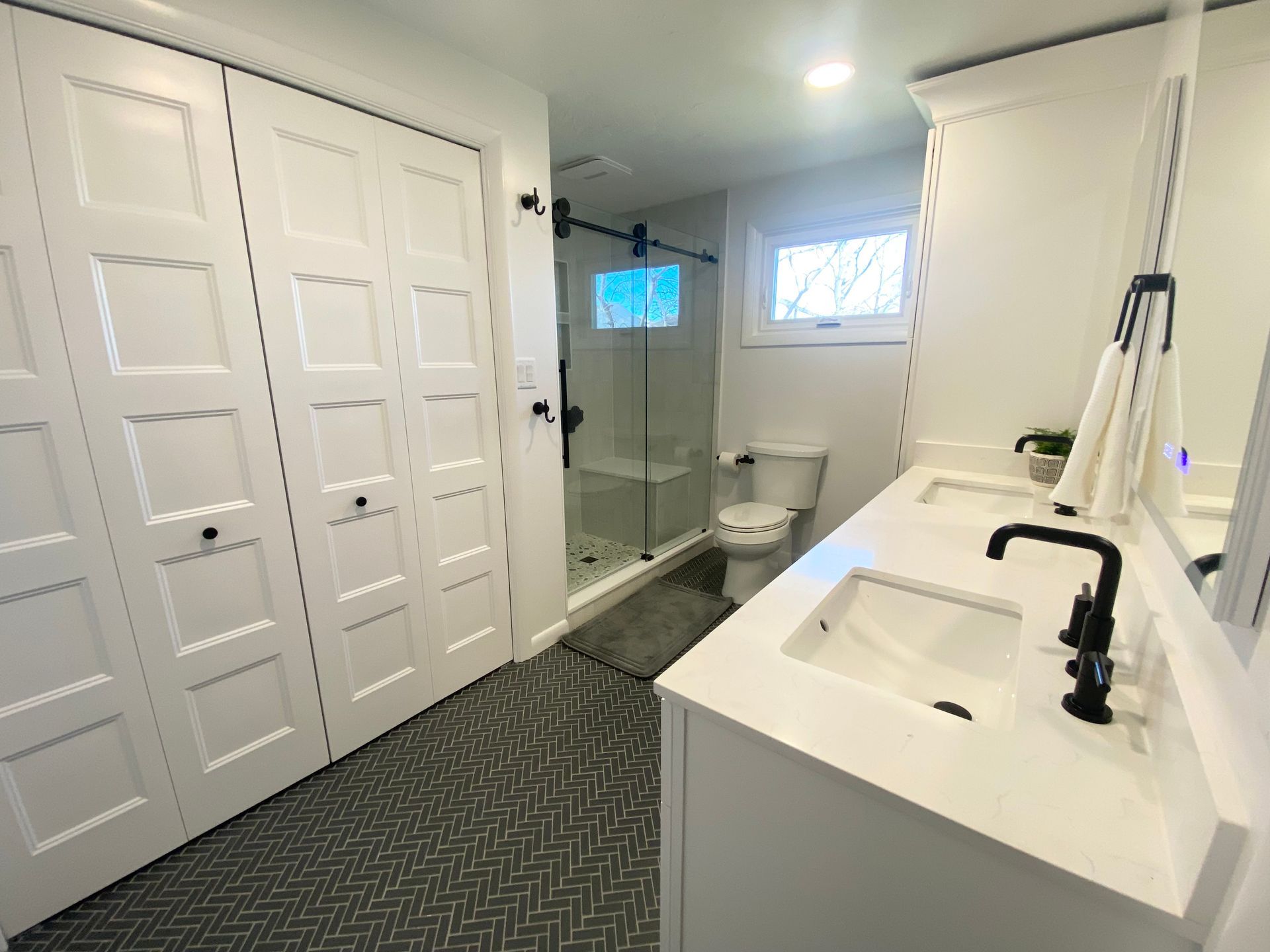 a bathroom with two sinks , a toilet , and a walk in shower .