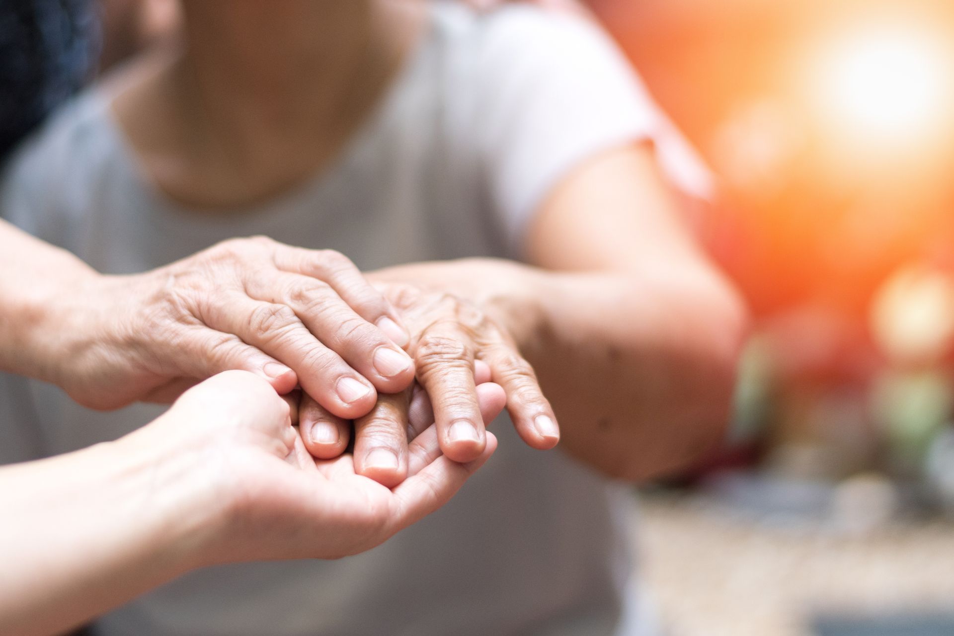Caregiver, carer hand holding elder hand woman in care. World Parkinson's Day