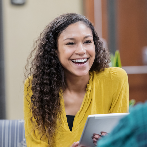 female social worker smiling while holding a tablet