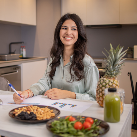 Female dietician holding red bell pepper while taking to patient