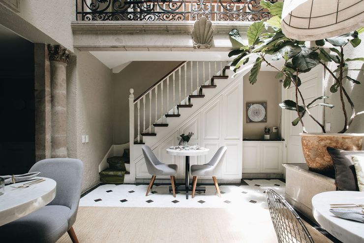 A living room with a table and chairs under a staircase.