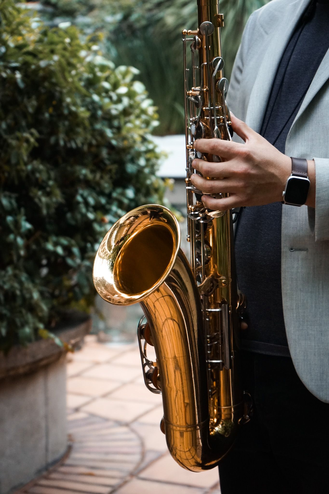 A man in a suit is holding a saxophone in his hands.