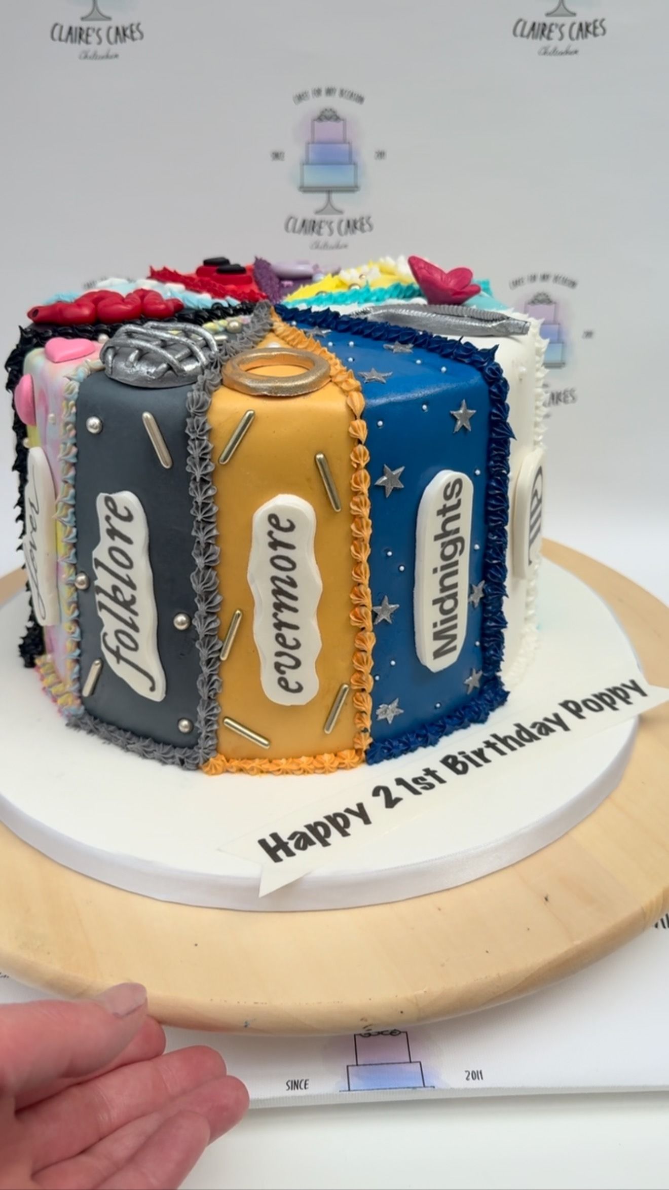 A decorated cake with sections themed after albums labeled