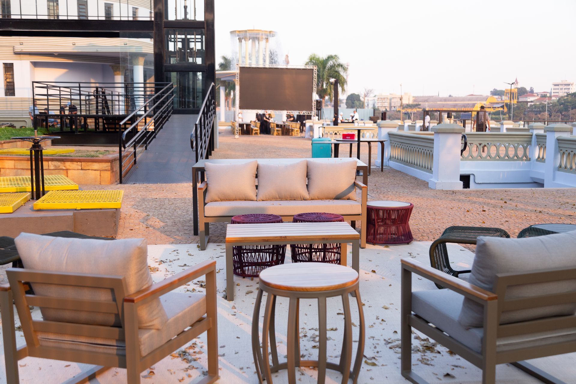 Uma área de pátio com um sofá, cadeiras e mesas