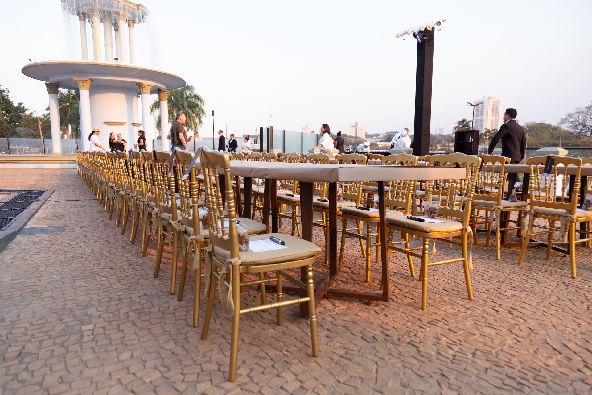 Uma fileira de mesas e cadeiras em uma calçada de tijolos
