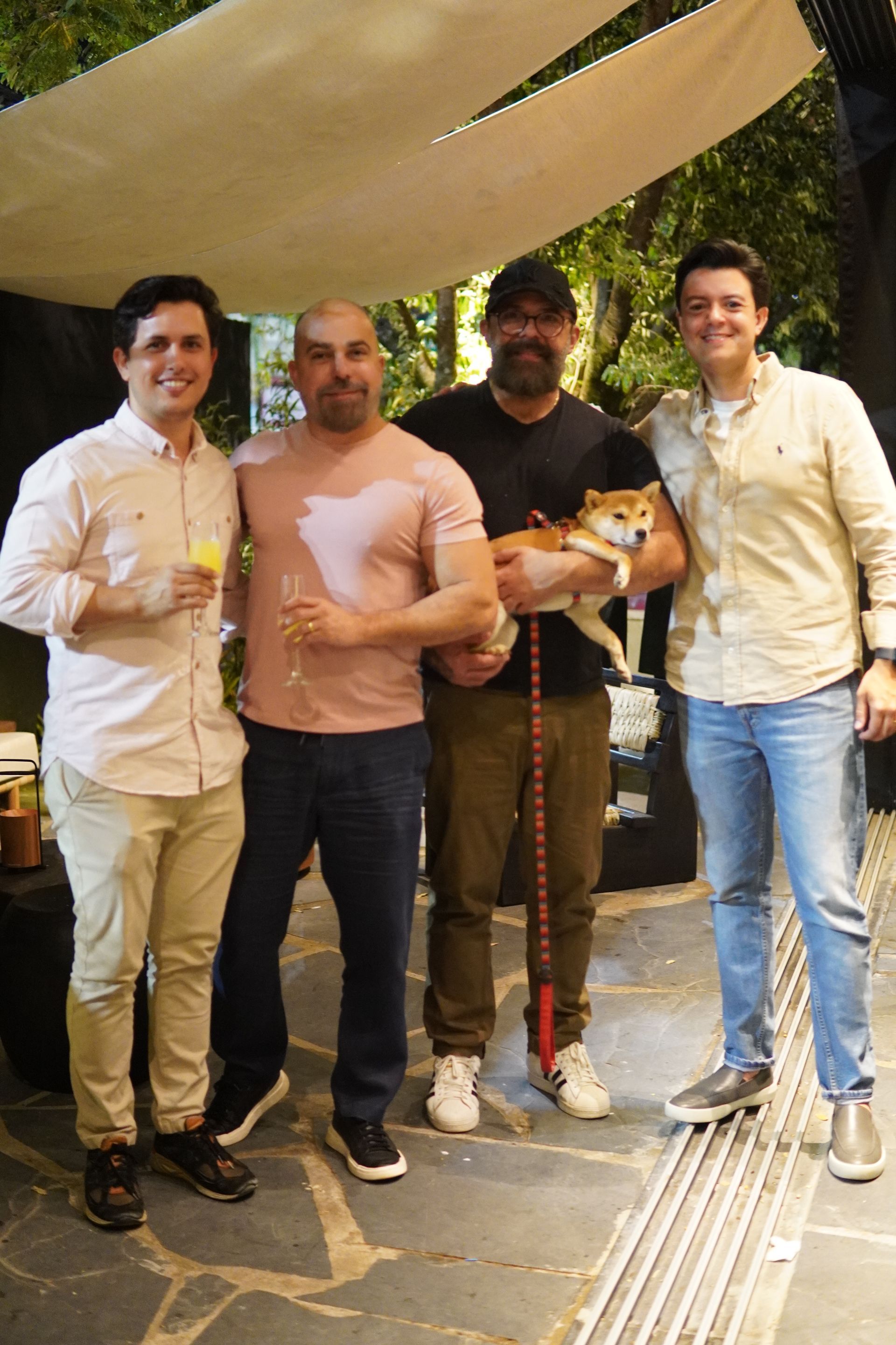 Um grupo de homens está posando para uma foto com um cachorro.
