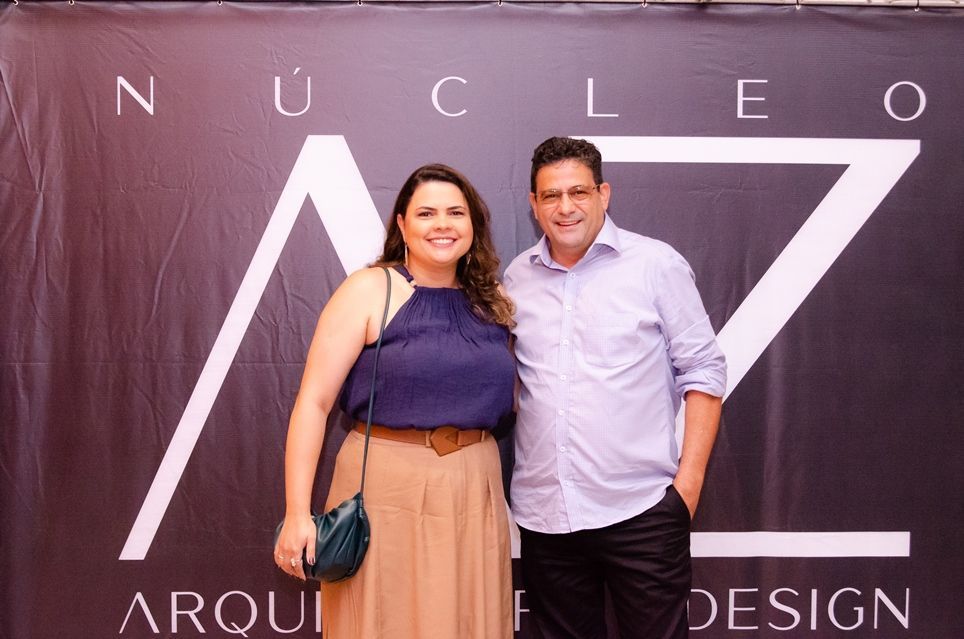 Um homem e uma mulher estão posando para uma foto em frente a uma placa que diz projeto nuclear.