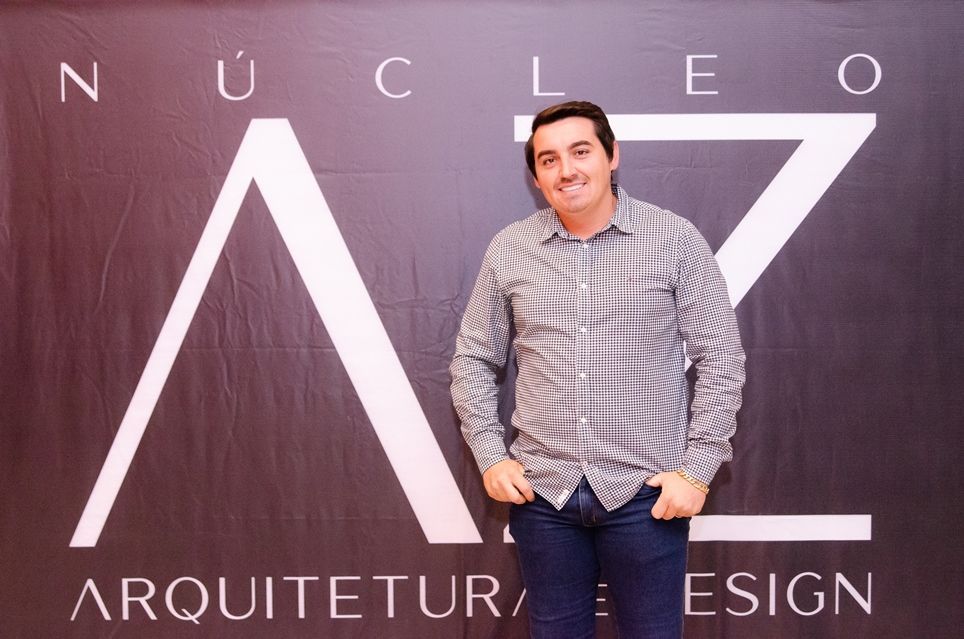 Um homem está em frente a uma placa que diz nucleo