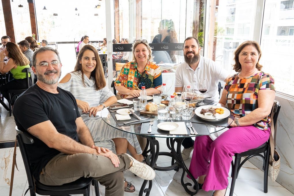 Um grupo de pessoas está sentado à mesa em um restaurante.