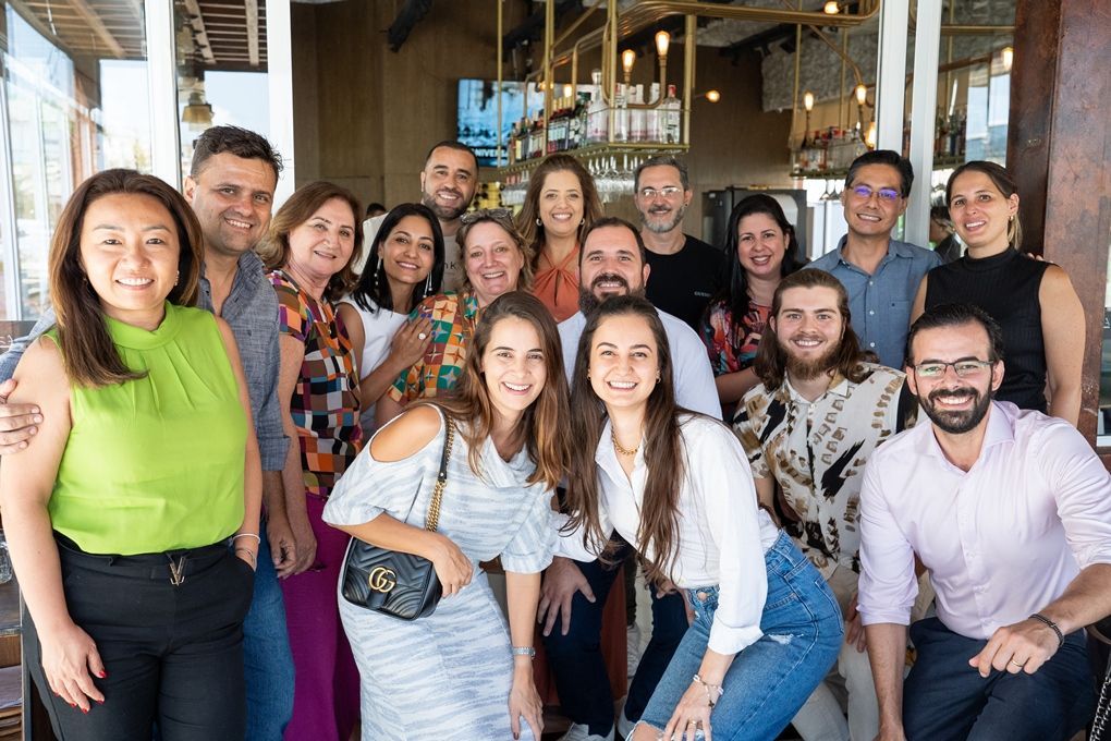 Um grupo de pessoas está posando para uma foto em frente a um restaurante.