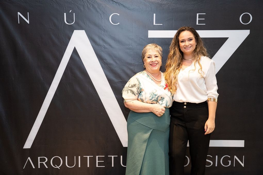 Duas mulheres em pé em frente a uma placa que diz arquiteto