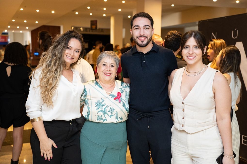 Um grupo de pessoas está posando para uma foto juntas em uma sala.