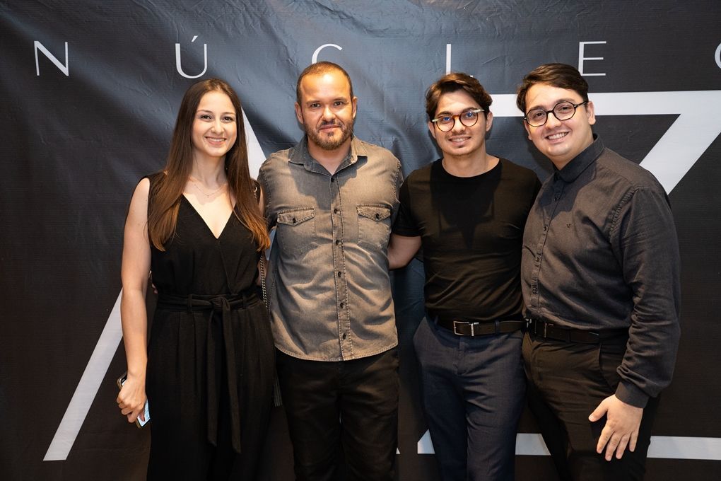 Um grupo de pessoas posando para uma foto em frente a uma placa que diz nuclear