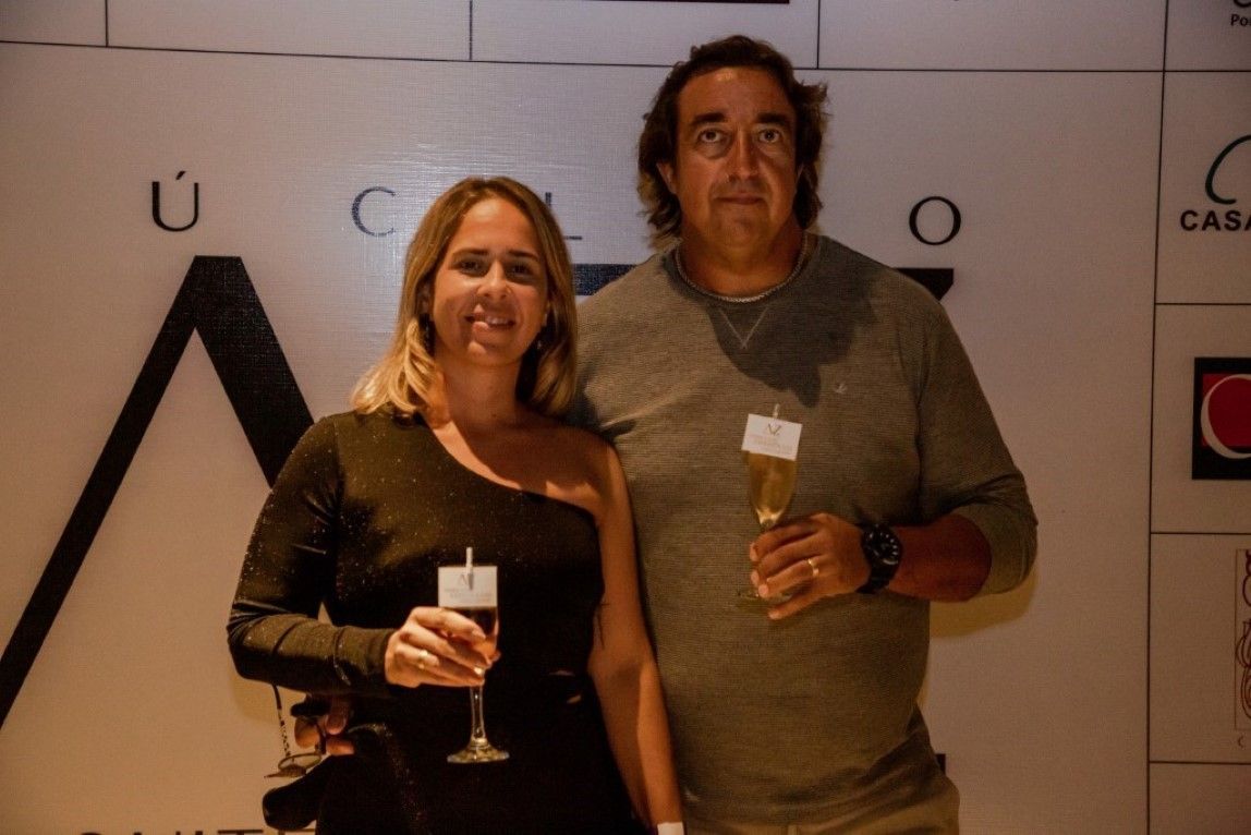 Um homem e uma mulher estão de pé, um ao lado do outro, segurando taças de champanhe.