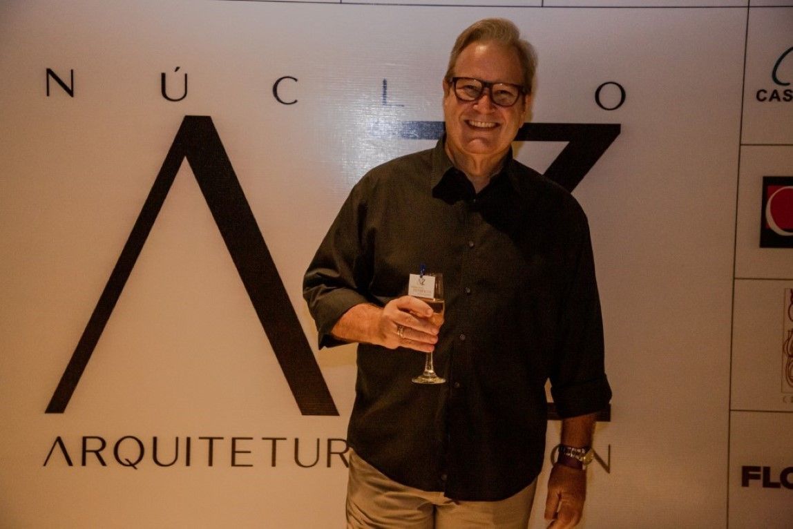 Um homem parado em frente a uma parede que diz arquiteto