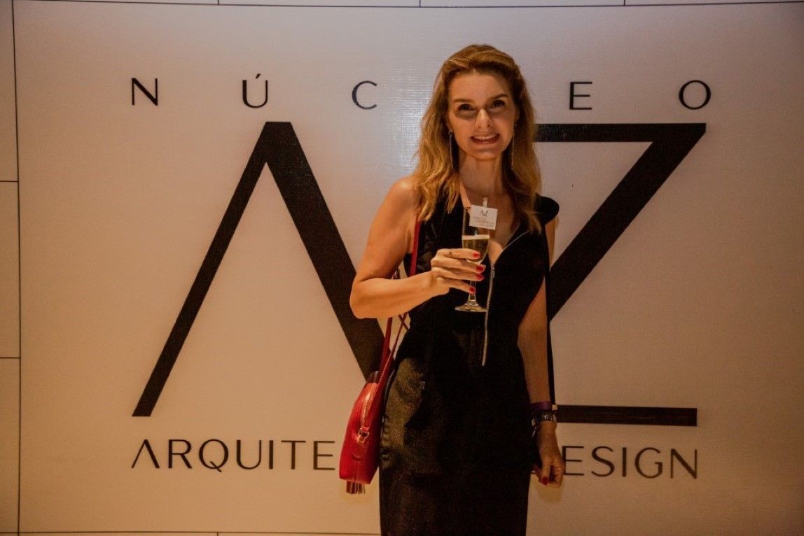 Uma mulher está parada em frente a uma placa que diz arquitete design