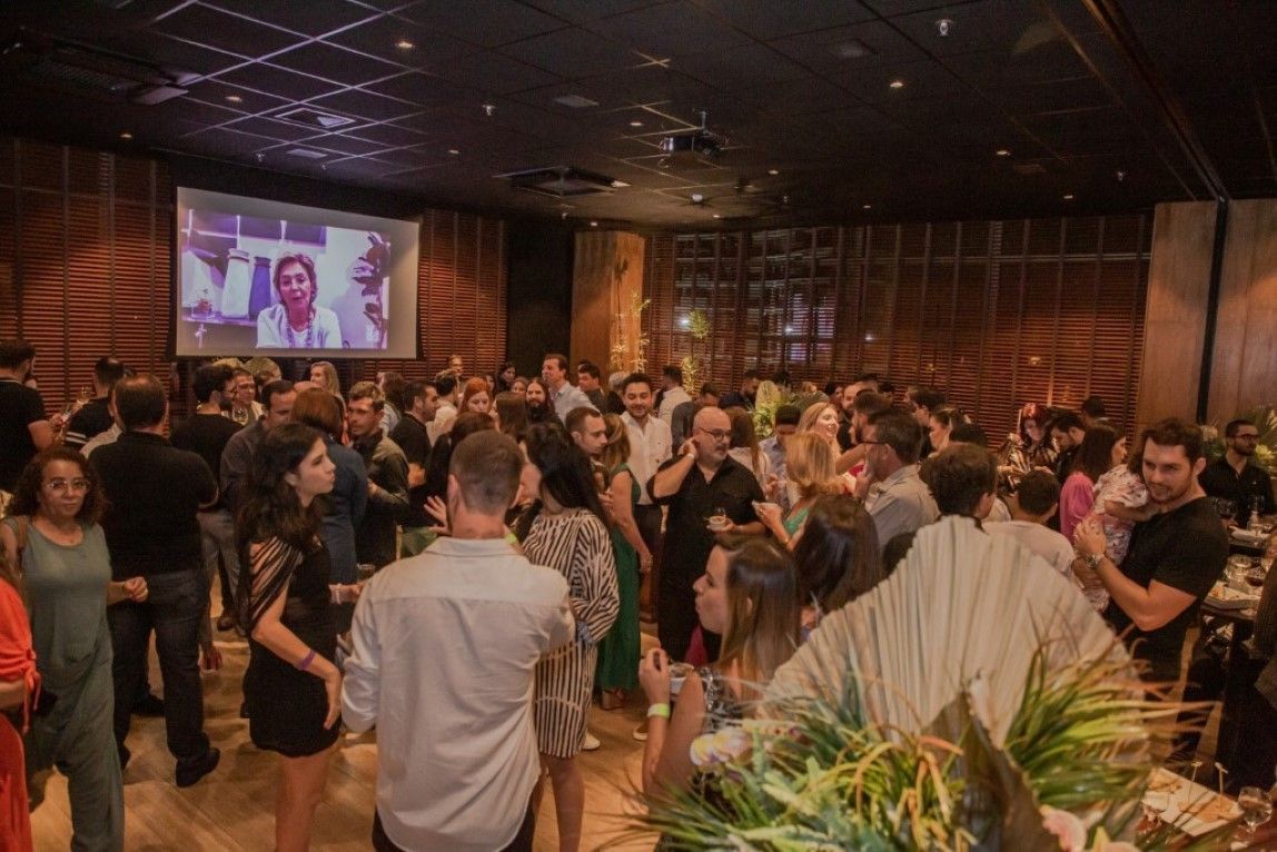 Um grande grupo de pessoas está dançando em uma sala grande.